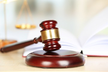 Wooden judges gavel on wooden table, close up