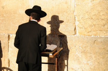 Religious orthodox jew praying at the Western wall in Jerusalem.